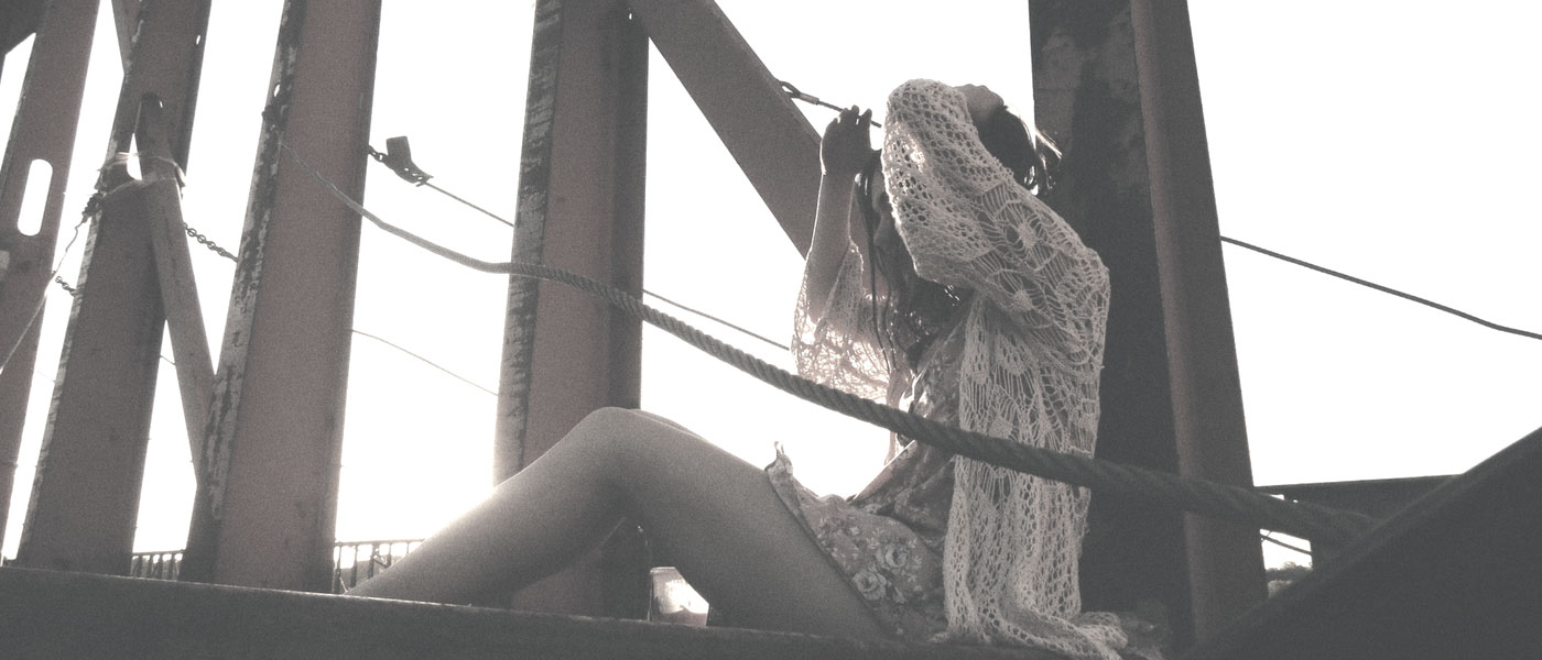 girl sitting on bridge exposing skin type to the sun