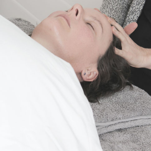 client on bed having natural face lift massage massage