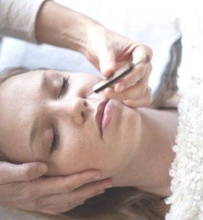 girl laying down having reflexology treatment with pointer tool