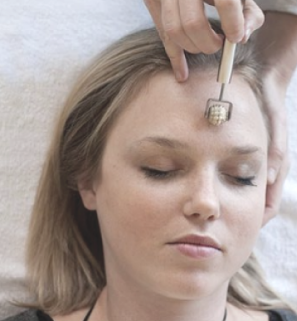 girl laying down having dien chan treatment with yang roller tool