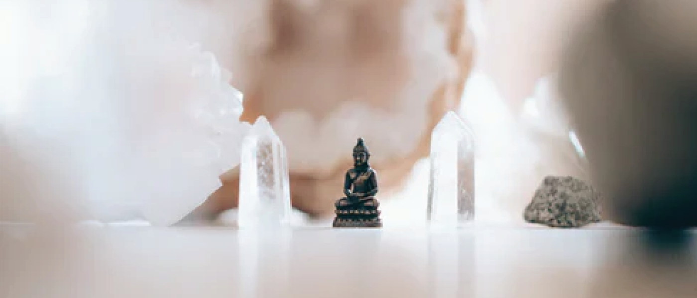 crystals on table with miniature Buddha statue